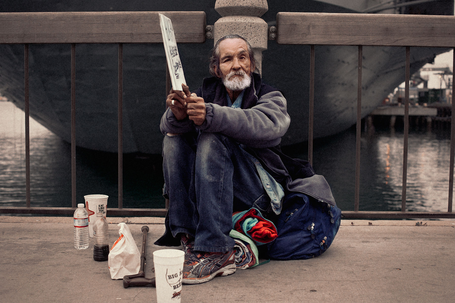 Good Boy Wolf Photographer, filmic portrait, homeless man holding a begging sign 
